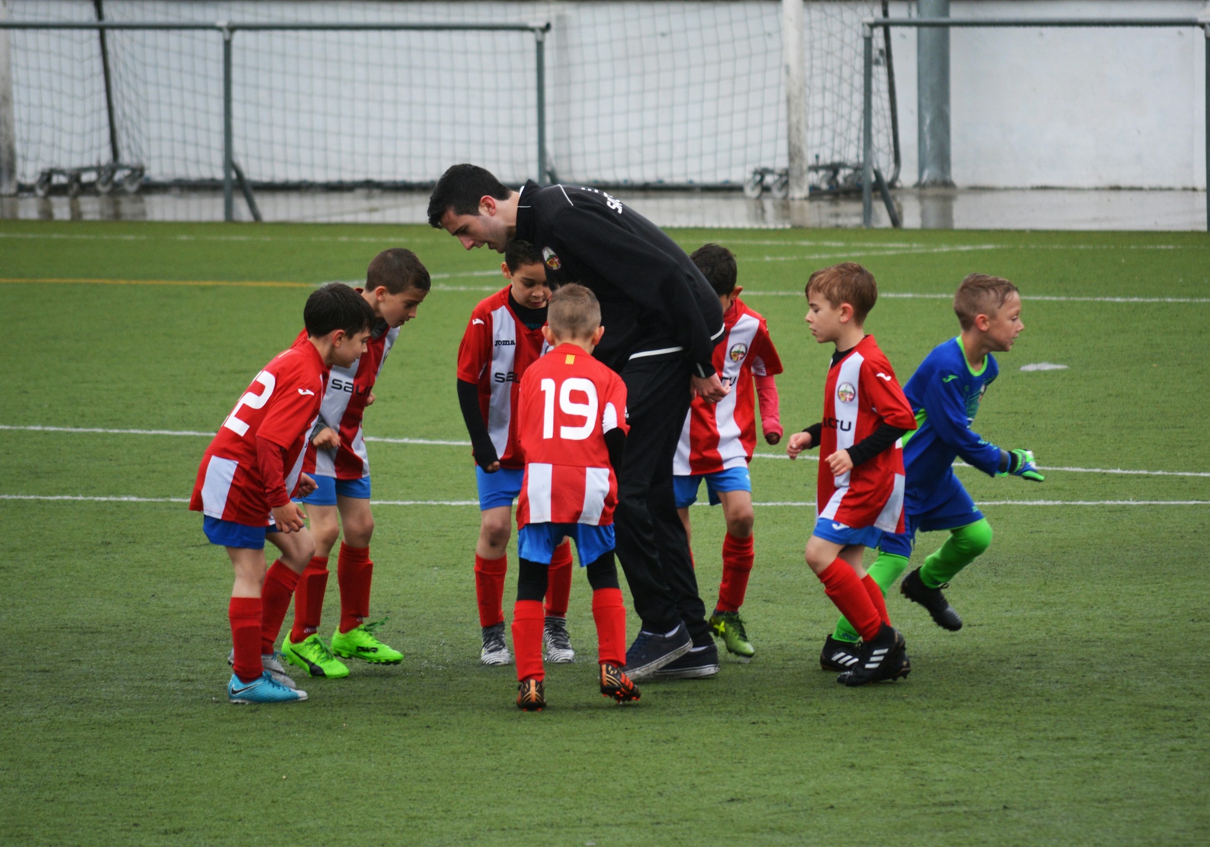 Soccer coach and child players in a huddle